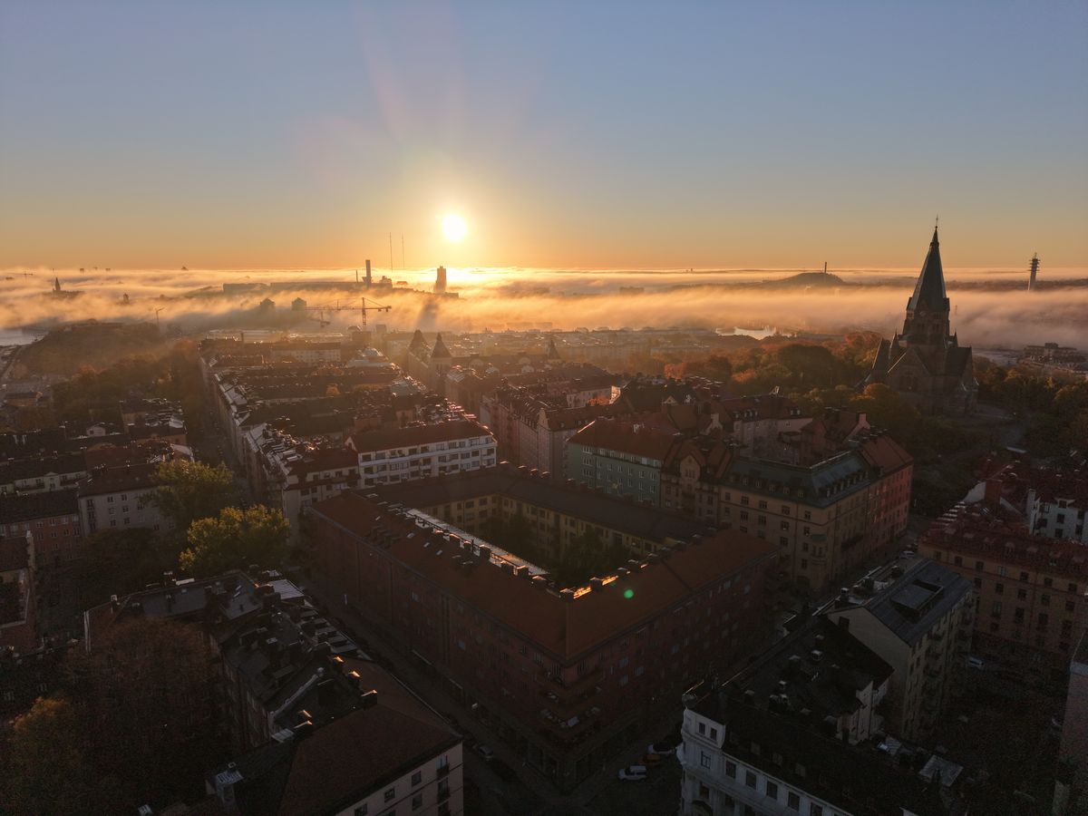Soluppgång över dimhavet på Södermalm, med Sofia kyrka till höger