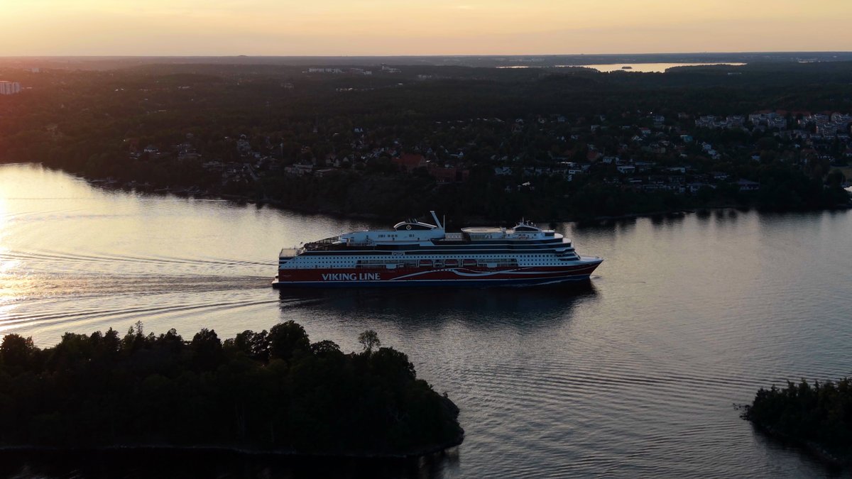 Kryssningsfärja som glider fram mellan holmar i kvällsljus