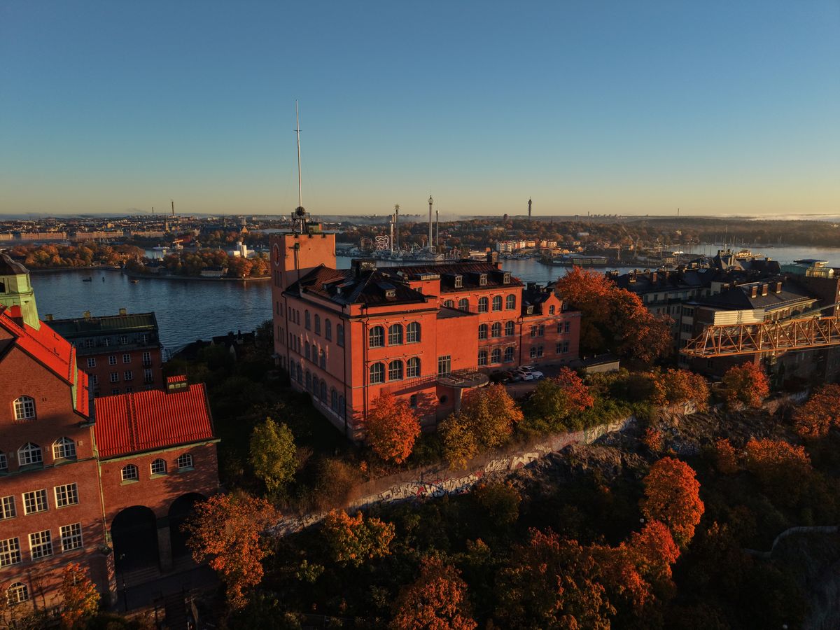 Röd byggnad i höstljus med utsikt över vattnet mot Gröna Lund