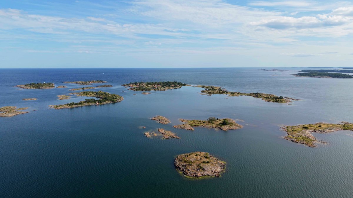 Små skär och kobbar i havsbandet sett från luften