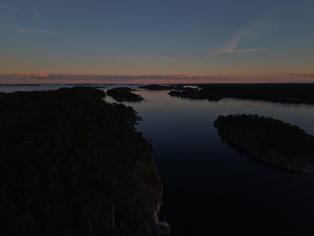Öar och stilla vatten i blå skymning