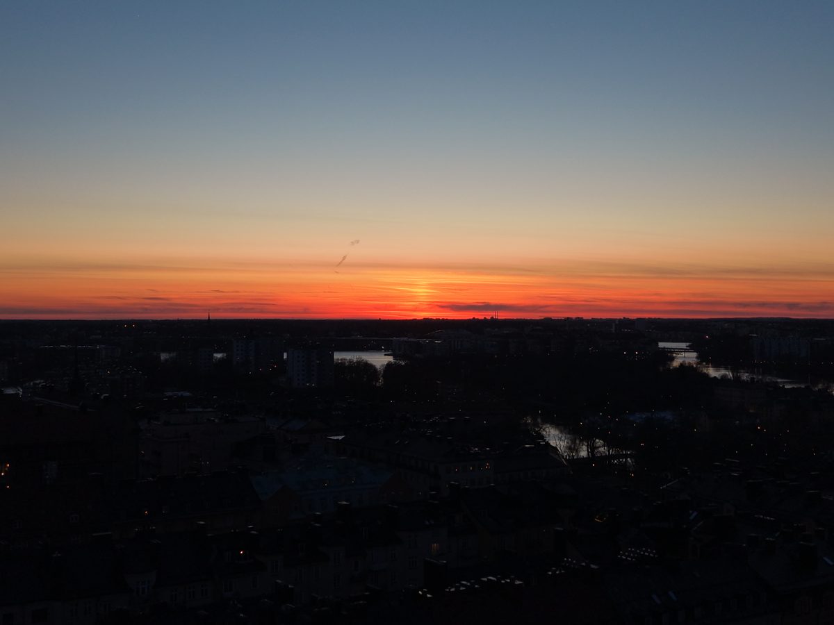 Orange solnedgång över stadens silhuett