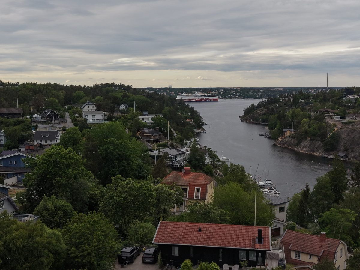 Smalt sund med båtar och hus på båda sidor
