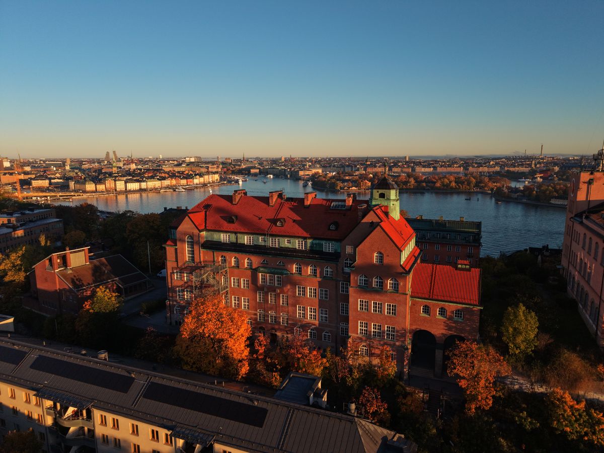Tegelbyggnad med rött tak och utsikt över vattnet mot Gamla stan