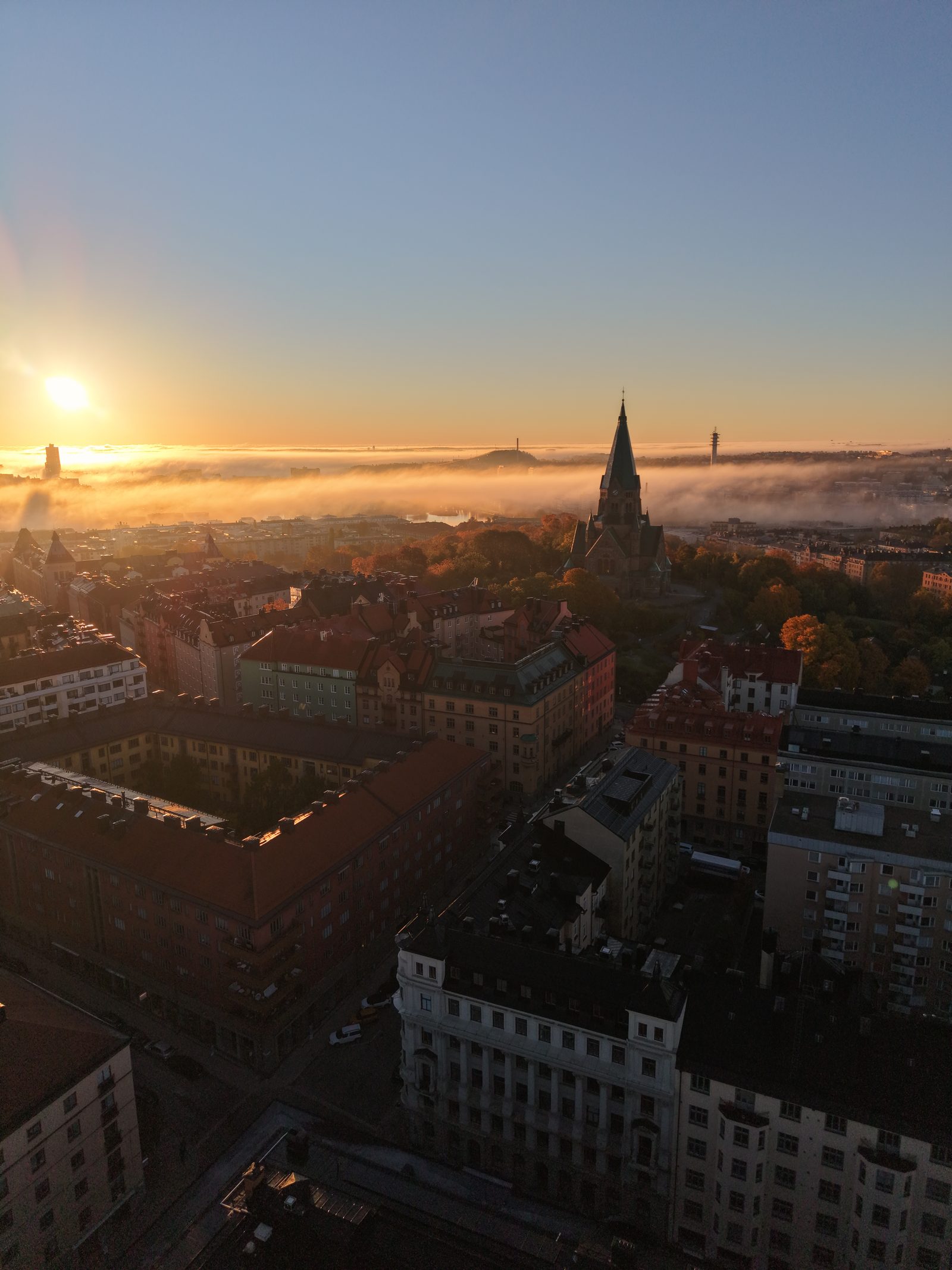 Soluppgång över dimhavet på Södermalm med Sofia kyrka, fotograferat med drönare